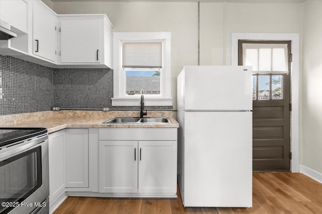 kitchen with sink, white cabinets, white refrigerator, light hardwood / wood-style floors, and stainless steel electric range