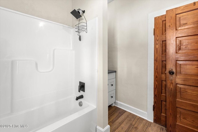 bathroom featuring washtub / shower combination and wood-type flooring