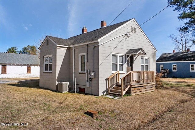 view of front of property with cooling unit and a front lawn