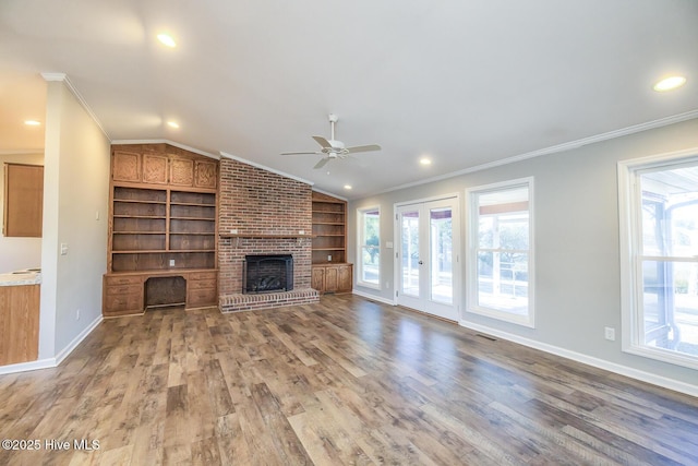 unfurnished living room featuring lofted ceiling, built in features, wood-type flooring, and ornamental molding