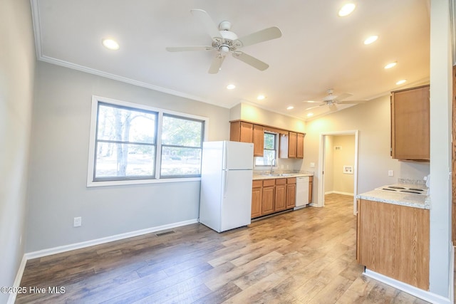 kitchen featuring sink, ornamental molding, light stone counters, light hardwood / wood-style floors, and white appliances