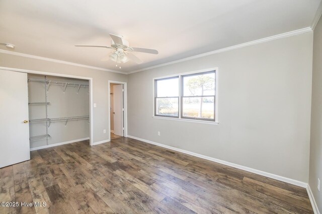 unfurnished bedroom with ceiling fan, ornamental molding, dark hardwood / wood-style floors, and a closet