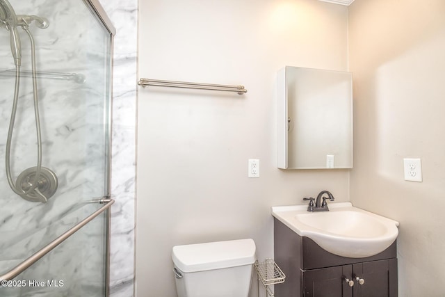 bathroom with vanity, tiled shower, and toilet