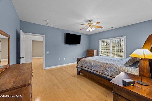 bedroom with a ceiling fan, visible vents, light wood-type flooring, and baseboards