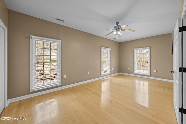 spare room featuring visible vents, light wood-style flooring, baseboards, and ceiling fan