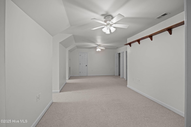 spare room featuring light carpet, visible vents, baseboards, and a ceiling fan