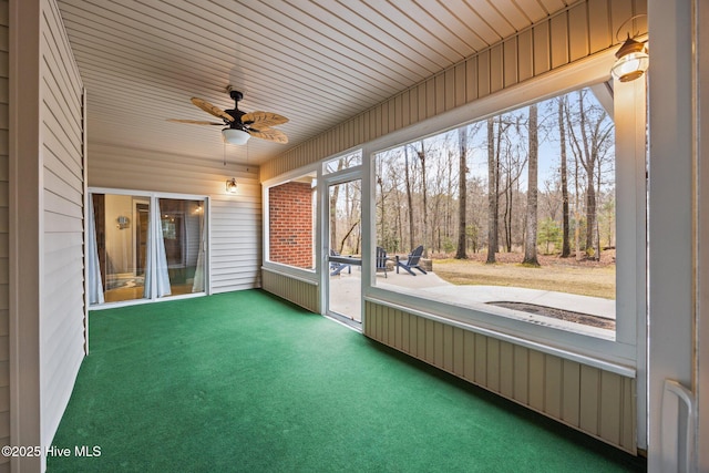 unfurnished sunroom featuring a ceiling fan