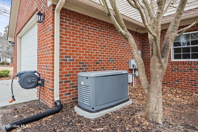 details featuring brick siding, electric meter, and a power unit