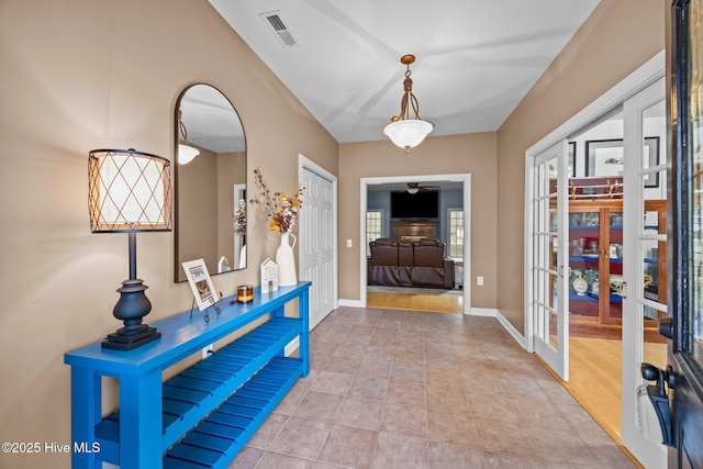 tiled entryway with a ceiling fan, french doors, visible vents, and baseboards