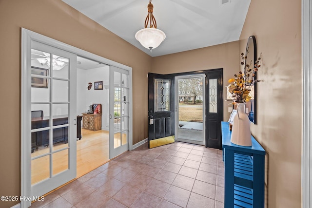 foyer entrance featuring tile patterned floors, visible vents, and baseboards