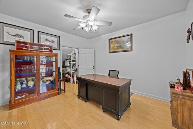 home office featuring light wood-type flooring, baseboards, and a ceiling fan