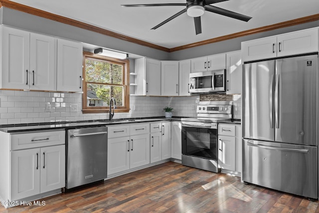 kitchen featuring dark wood finished floors, crown molding, dark countertops, backsplash, and appliances with stainless steel finishes