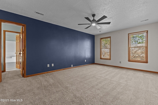 empty room with baseboards, visible vents, and carpet flooring