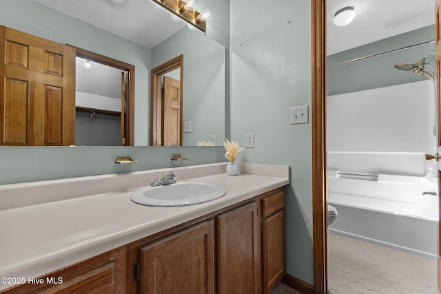 bathroom with toilet, vanity, and a textured ceiling