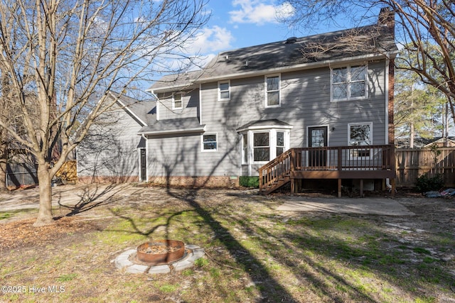 back of house with a chimney, stairway, fence, a fire pit, and a wooden deck