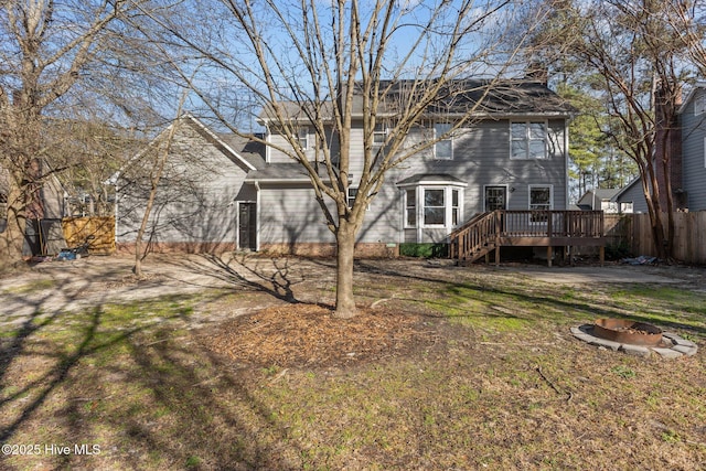 back of house featuring a yard, an outdoor fire pit, fence, and a wooden deck