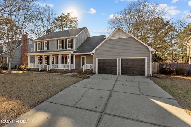 view of front of house featuring a garage, driveway, fence, and a porch