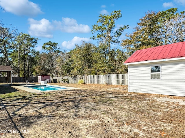 view of yard featuring a fenced in pool and a storage shed