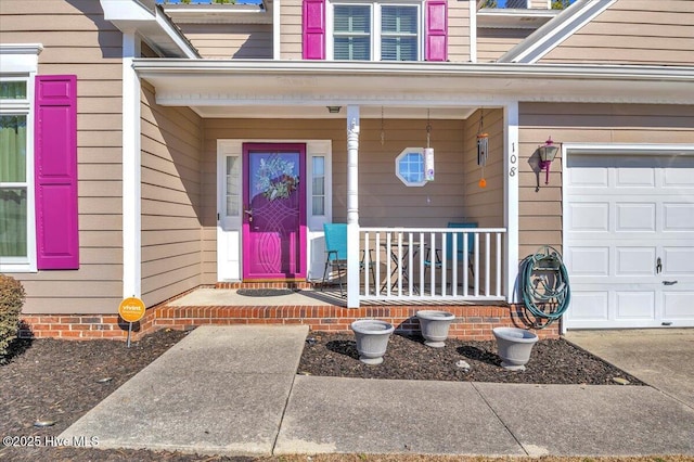 entrance to property with a garage and covered porch