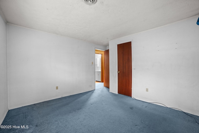 empty room with carpet flooring and a textured ceiling