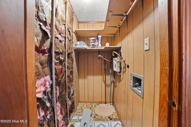 interior space with wooden walls and a textured ceiling