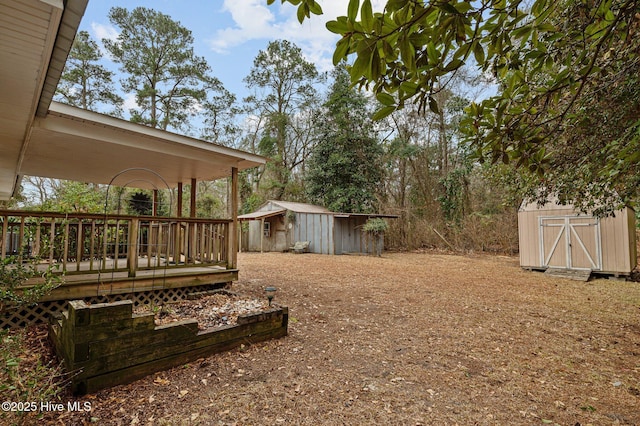 view of yard with a wooden deck and a storage unit