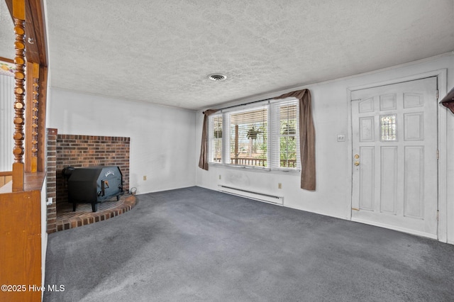 unfurnished living room with dark carpet, a wood stove, a textured ceiling, and baseboard heating