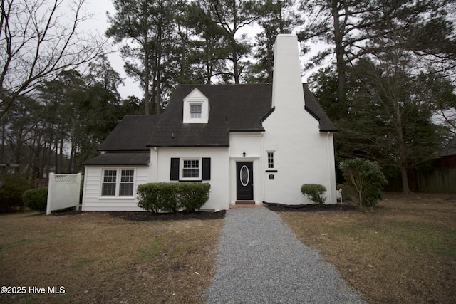 cape cod house featuring a front lawn