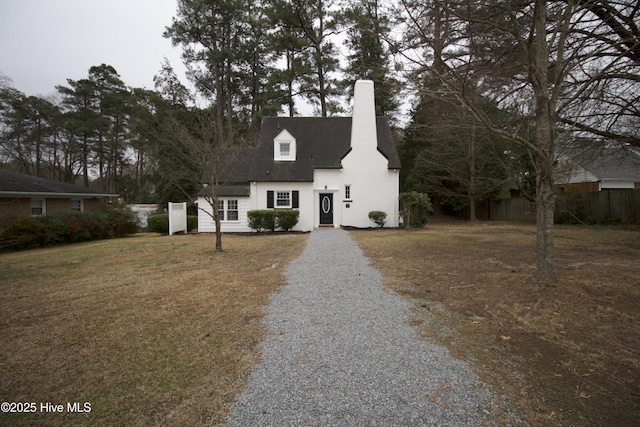 cape cod home with a front lawn