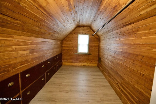 additional living space featuring vaulted ceiling, wooden ceiling, light wood-type flooring, and wood walls