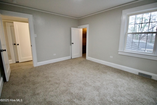 unfurnished bedroom featuring light colored carpet and ornamental molding