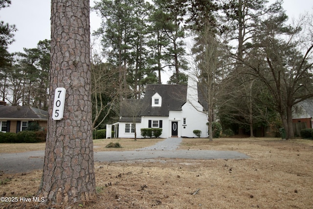 cape cod-style house featuring a front lawn