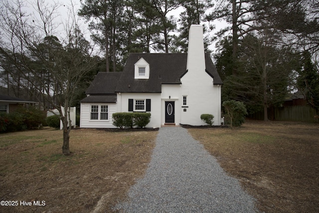 cape cod-style house with a front lawn