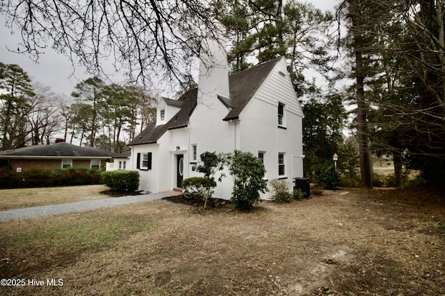 view of front of property with central AC unit and a front lawn