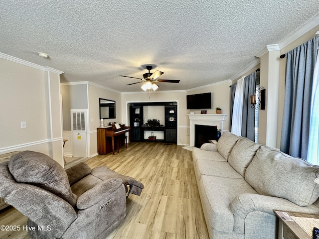 living room featuring crown molding, a textured ceiling, ceiling fan, and light hardwood / wood-style flooring