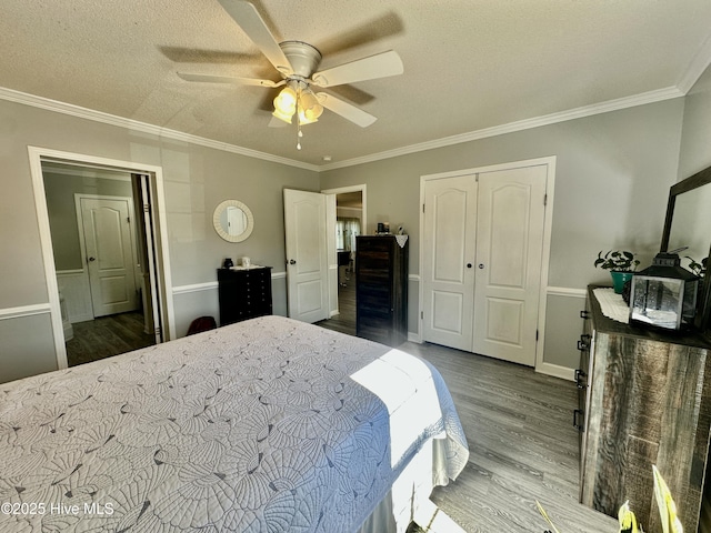 bedroom featuring hardwood / wood-style flooring, ornamental molding, ceiling fan, a textured ceiling, and a closet