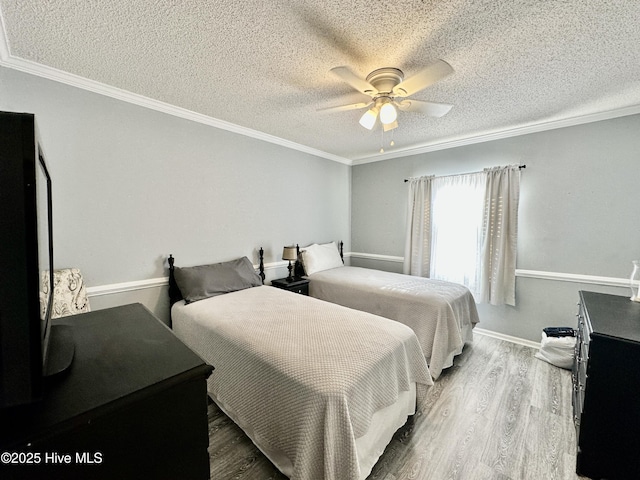 bedroom featuring crown molding, ceiling fan, wood-type flooring, and a textured ceiling