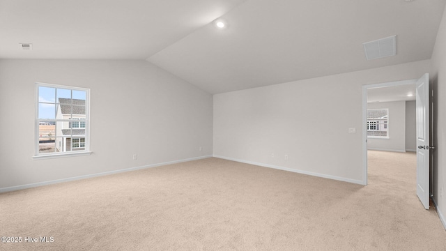 bonus room featuring light colored carpet, a healthy amount of sunlight, and vaulted ceiling