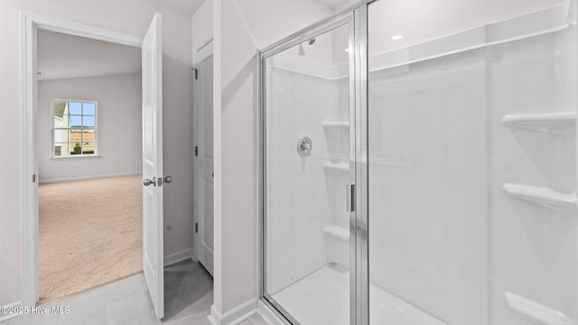 bathroom with a shower with shower door and vaulted ceiling