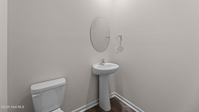 bathroom featuring wood-type flooring and toilet