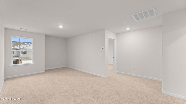 spare room featuring light carpet