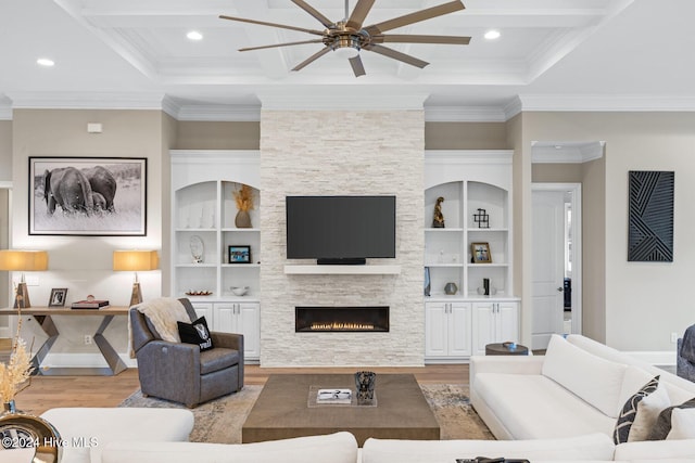 living room with crown molding, a stone fireplace, coffered ceiling, and light wood-type flooring