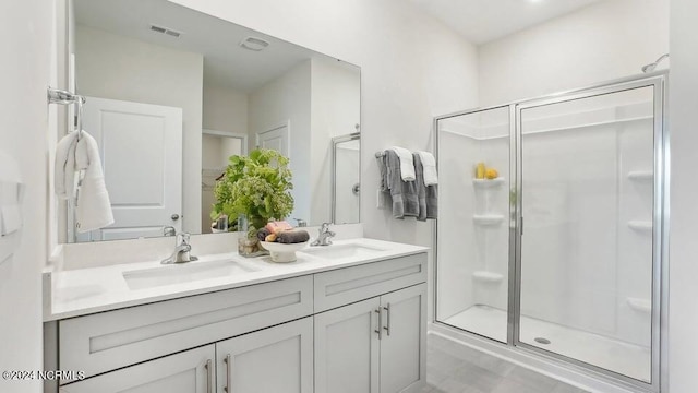 bathroom featuring a shower with door and vanity