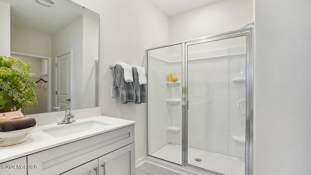 bathroom featuring vanity and a shower with door