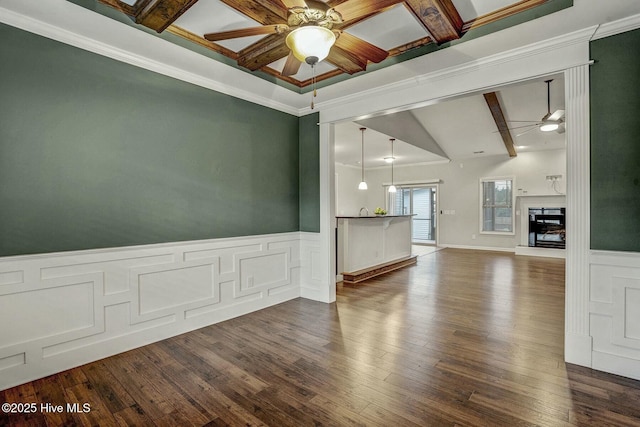 unfurnished living room with ceiling fan, ornamental molding, dark hardwood / wood-style floors, and vaulted ceiling with beams