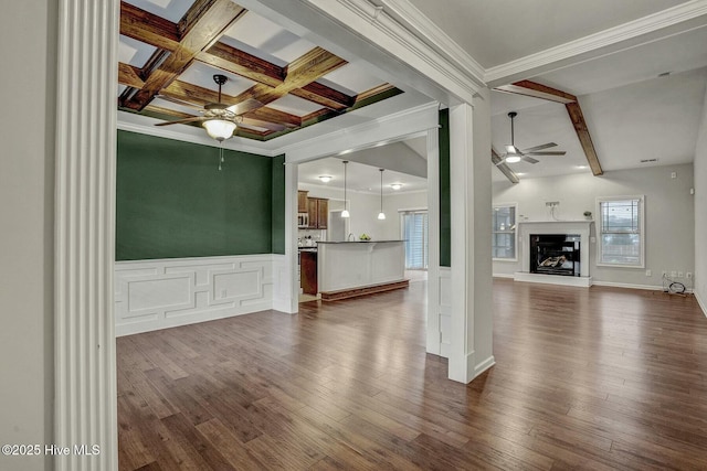 unfurnished living room with ceiling fan, crown molding, dark hardwood / wood-style floors, and beamed ceiling