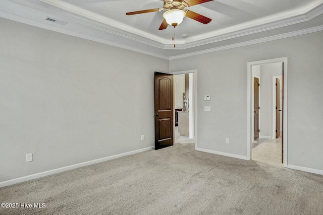 spare room with crown molding, light colored carpet, a raised ceiling, and ceiling fan