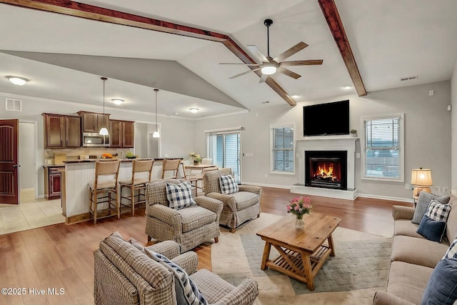 living room with lofted ceiling with beams, light hardwood / wood-style floors, and ceiling fan