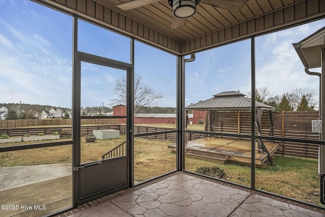 unfurnished sunroom featuring ceiling fan