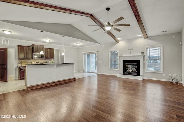 unfurnished living room featuring ceiling fan, beam ceiling, high vaulted ceiling, and light wood-type flooring